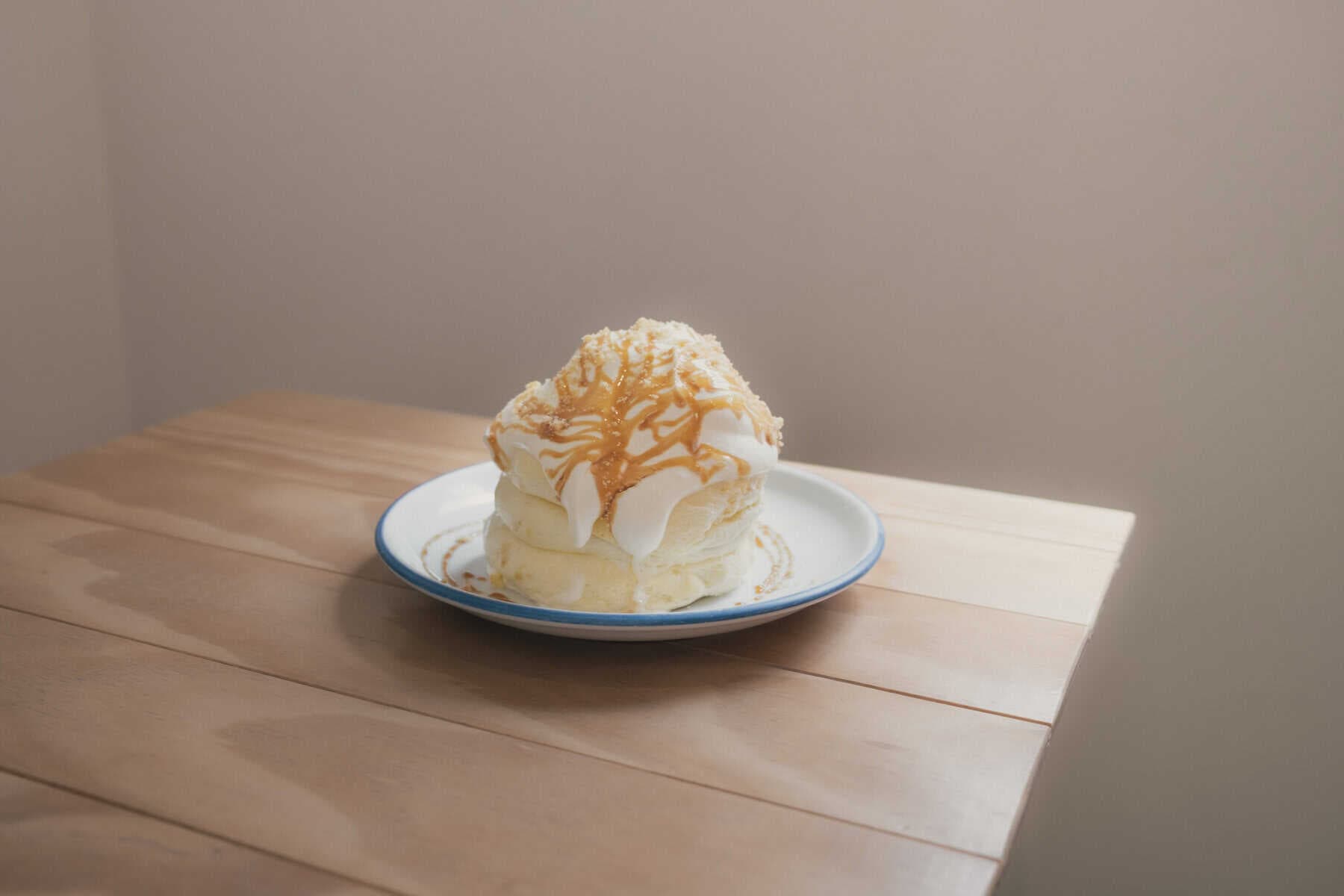 東京茶香舒芙蕾鬆餅店的招牌『星』，三層舒芙蕾搭配鮮奶油與焦糖醬，撒上焦糖餅乾碎點綴。