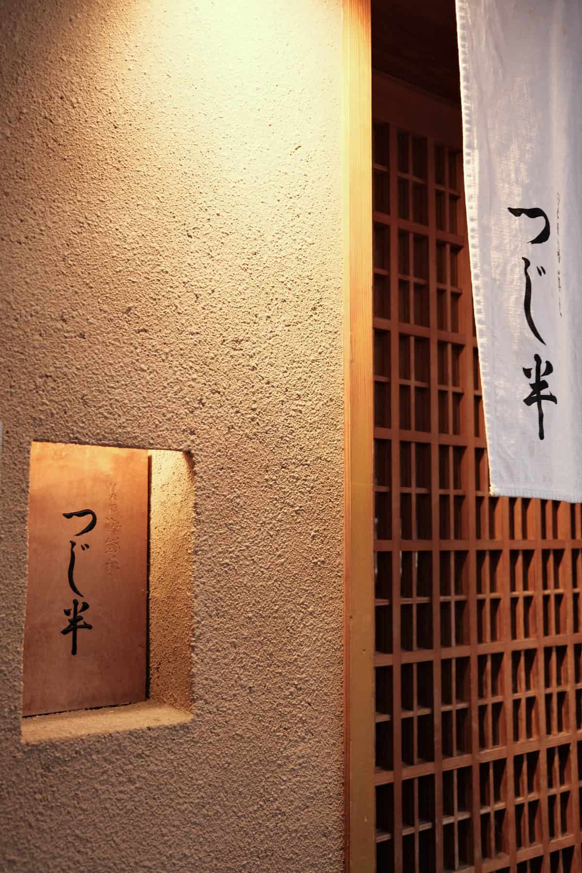 日本餐廳外觀,牆面上掛有簡約設計的餐廳名稱。